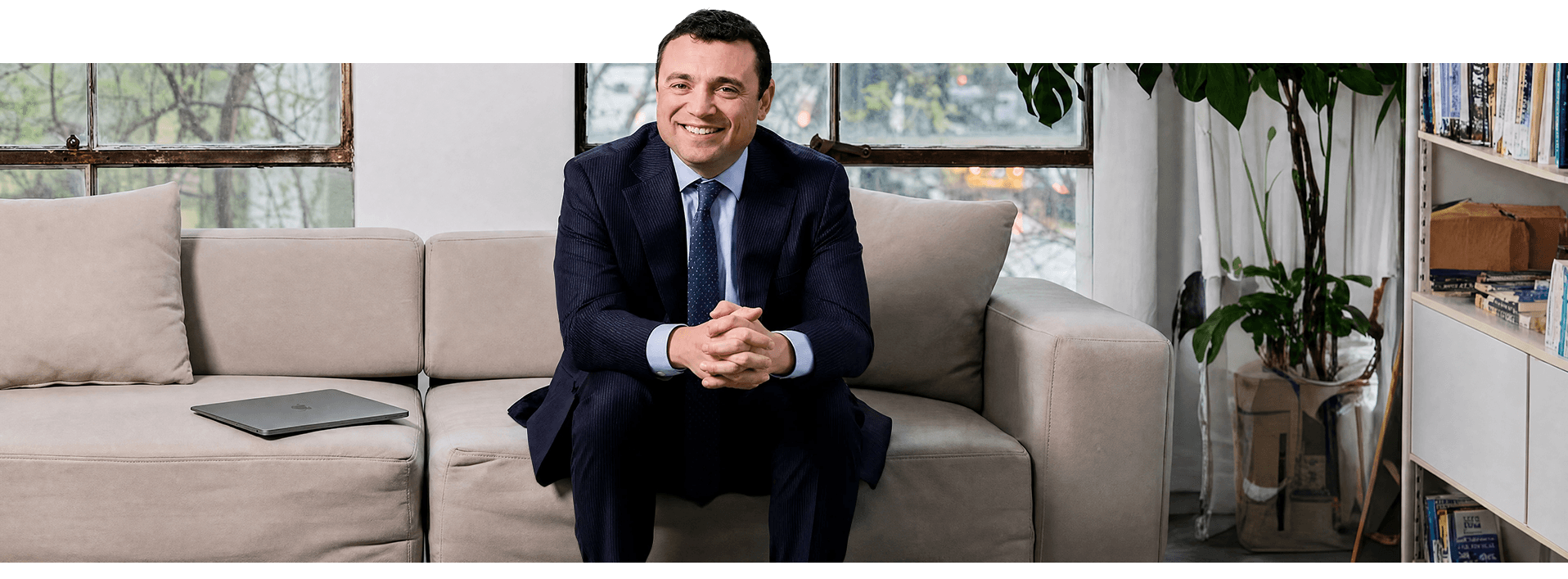 Sam Pastor seated on a couch